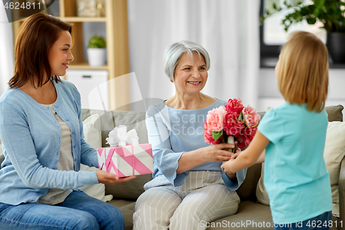 Image of granddaughter giving flowers to grandmother