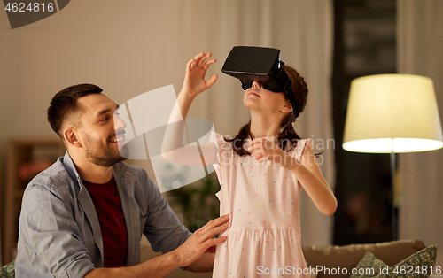 Image of father and daughter in vr glasses playing at home