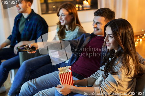 Image of friends with popcorn watching tv at home