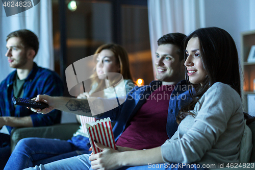 Image of friends with popcorn watching tv at home