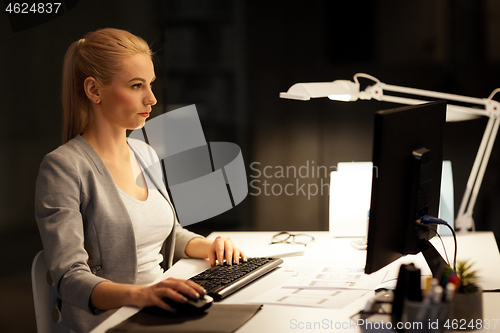 Image of businesswoman at computer working at night office