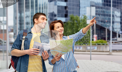 Image of happy couple of tourists with city guide and map