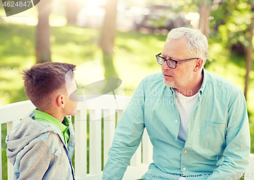 Image of grandfather and grandson talking at summer park