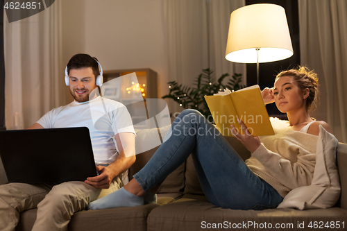 Image of couple with laptop computer and book at home