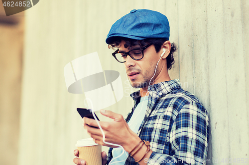 Image of man with earphones and smartphone drinking coffee