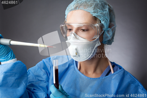 Image of Medical pathologist or research scientist working in a lab with 