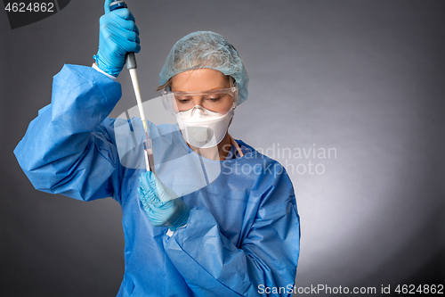 Image of Medical laboratory worker using a pipette to sample blood test f