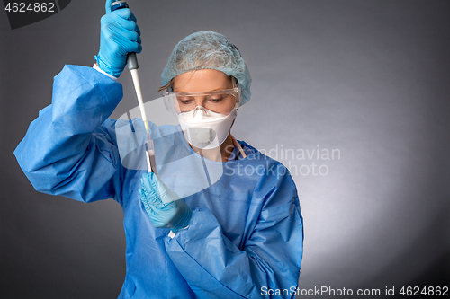 Image of Medical laboratory worker using a pipette to sample blood test f