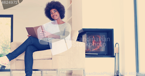 Image of black woman at home reading book