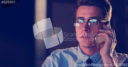 Image of man using mobile phone in dark office