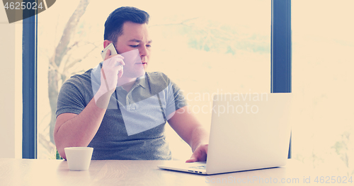 Image of businessman working using a laptop in startup office