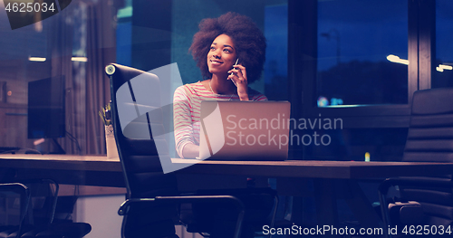 Image of black businesswoman using a laptop in night startup office