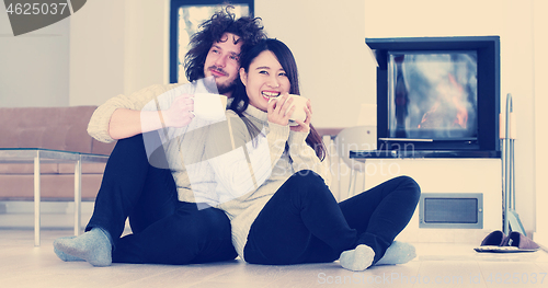 Image of multiethnic romantic couple  in front of fireplace