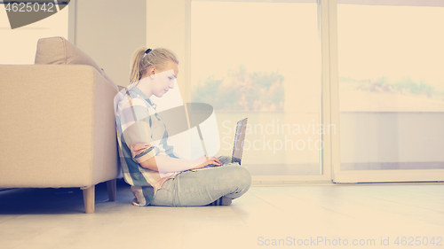 Image of young women using laptop computer on the floor