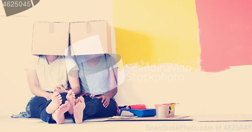 Image of young multiethnic couple playing with cardboard boxes