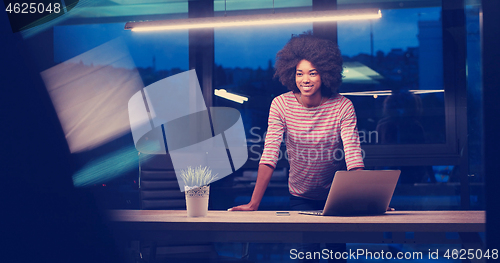 Image of black businesswoman using a laptop in night startup office