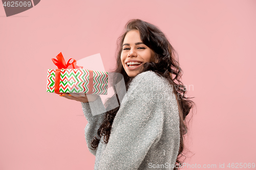 Image of Woman with big beautiful smile holding colorful gift box.