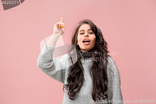 Image of The happy business woman standing and smiling against pastel background.