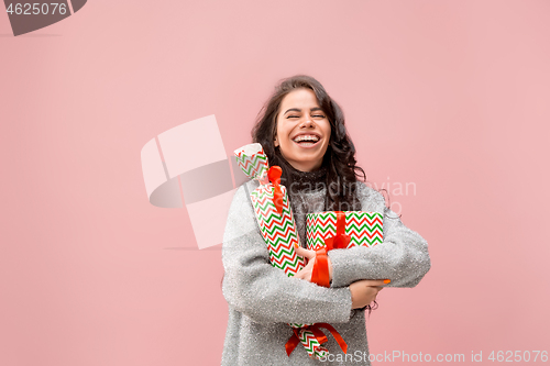 Image of Woman with big beautiful smile holding colorful gift boxes.