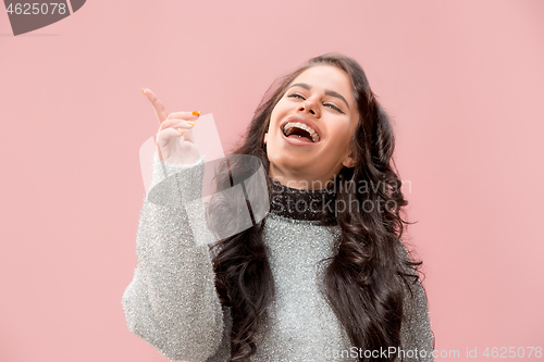 Image of The happy business woman standing and smiling against pastel background.