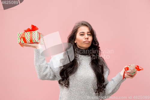 Image of Woman with big beautiful smile holding colorful gift boxes.