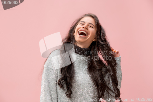 Image of The happy business woman standing and smiling against pastel background.