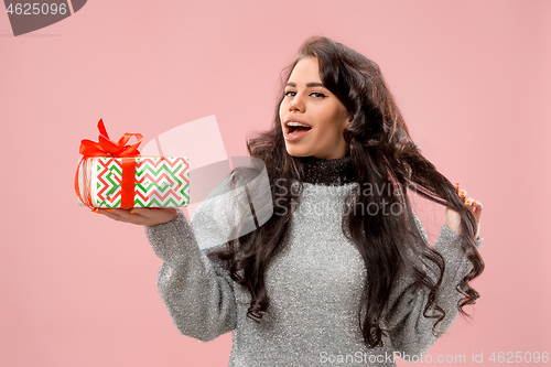 Image of Woman with big beautiful smile holding colorful gift box.
