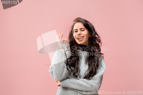 Image of The happy business woman standing and smiling against pink background.