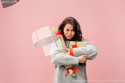 Image of Woman with big beautiful smile holding colorful gift boxes.