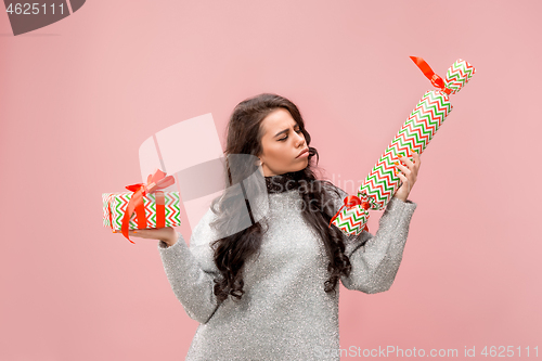 Image of Woman with big beautiful smile holding colorful gift boxes.