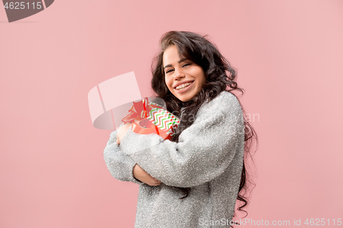 Image of Woman with big beautiful smile holding colorful gift box.