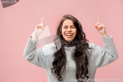 Image of The happy business woman standing and smiling against pastel background.