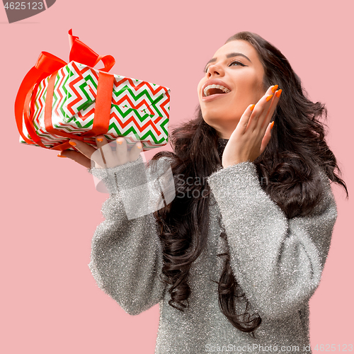 Image of Woman with big beautiful smile holding colorful gift box.