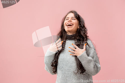 Image of The happy business woman standing and smiling against pastel background.