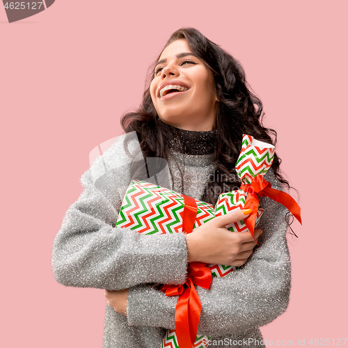 Image of Woman with big beautiful smile holding colorful gift boxes.