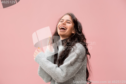 Image of The happy business woman standing and smiling against pastel background.