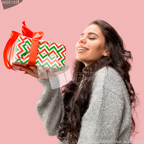 Image of Woman with big beautiful smile holding colorful gift box.