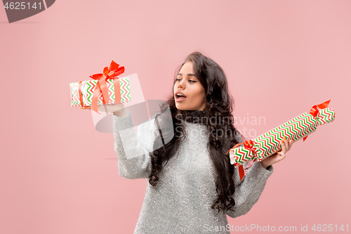 Image of Woman with big beautiful smile holding colorful gift boxes.