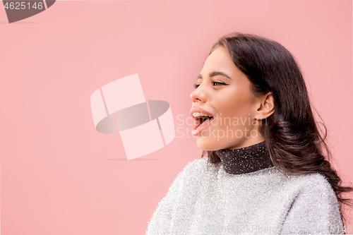 Image of The happy business woman standing and smiling against pastel background.