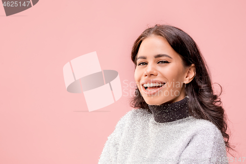 Image of The happy business woman standing and smiling against pastel background.