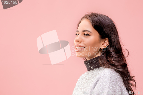 Image of The happy business woman standing and smiling against pastel background.