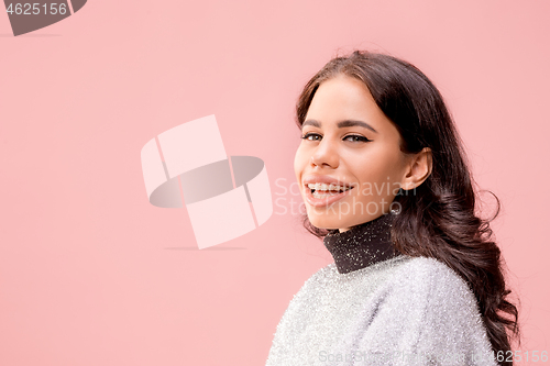 Image of The happy business woman standing and smiling against pastel background.