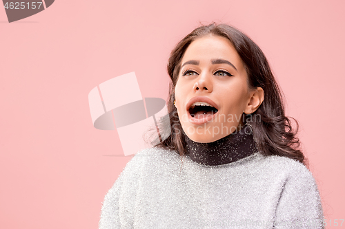 Image of Beautiful woman looking suprised isolated on pink