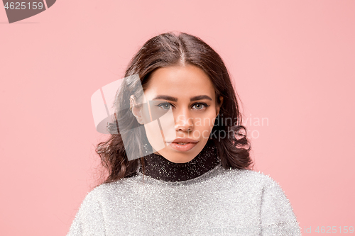 Image of Serious business woman standing, looking at camera isolated on trendy pink studio background.