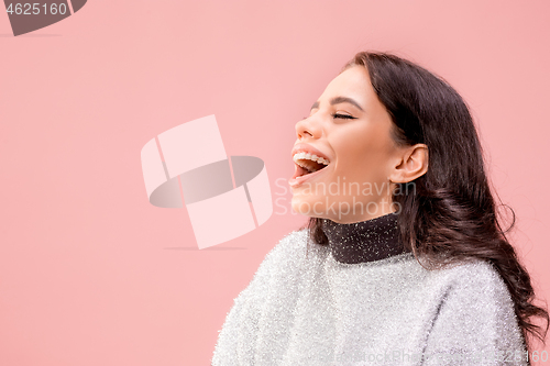 Image of The happy business woman standing and smiling against pastel background.