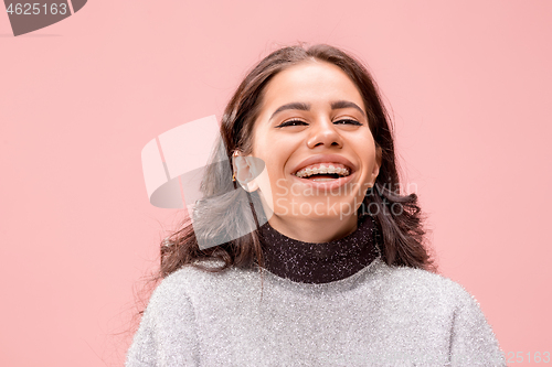 Image of The happy business woman standing and smiling against pastel background.