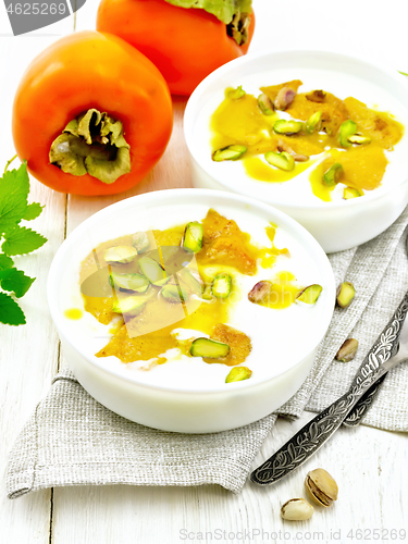 Image of Dessert of yogurt and persimmon two bowls on light board