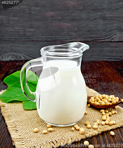 Image of Milk soy in jug with beans on dark board