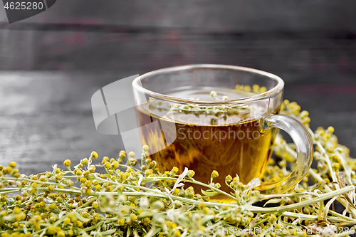 Image of Tea of gray wormwood in glass cup on dark board