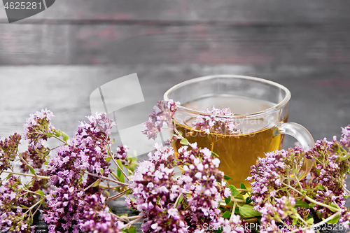 Image of Tea of oregano in glass cup on board